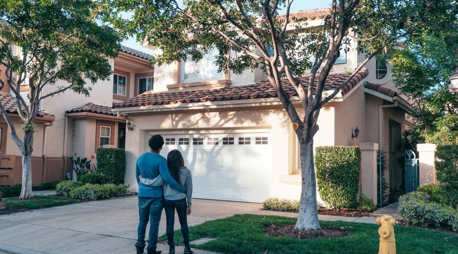 couple looking up at home from driveway