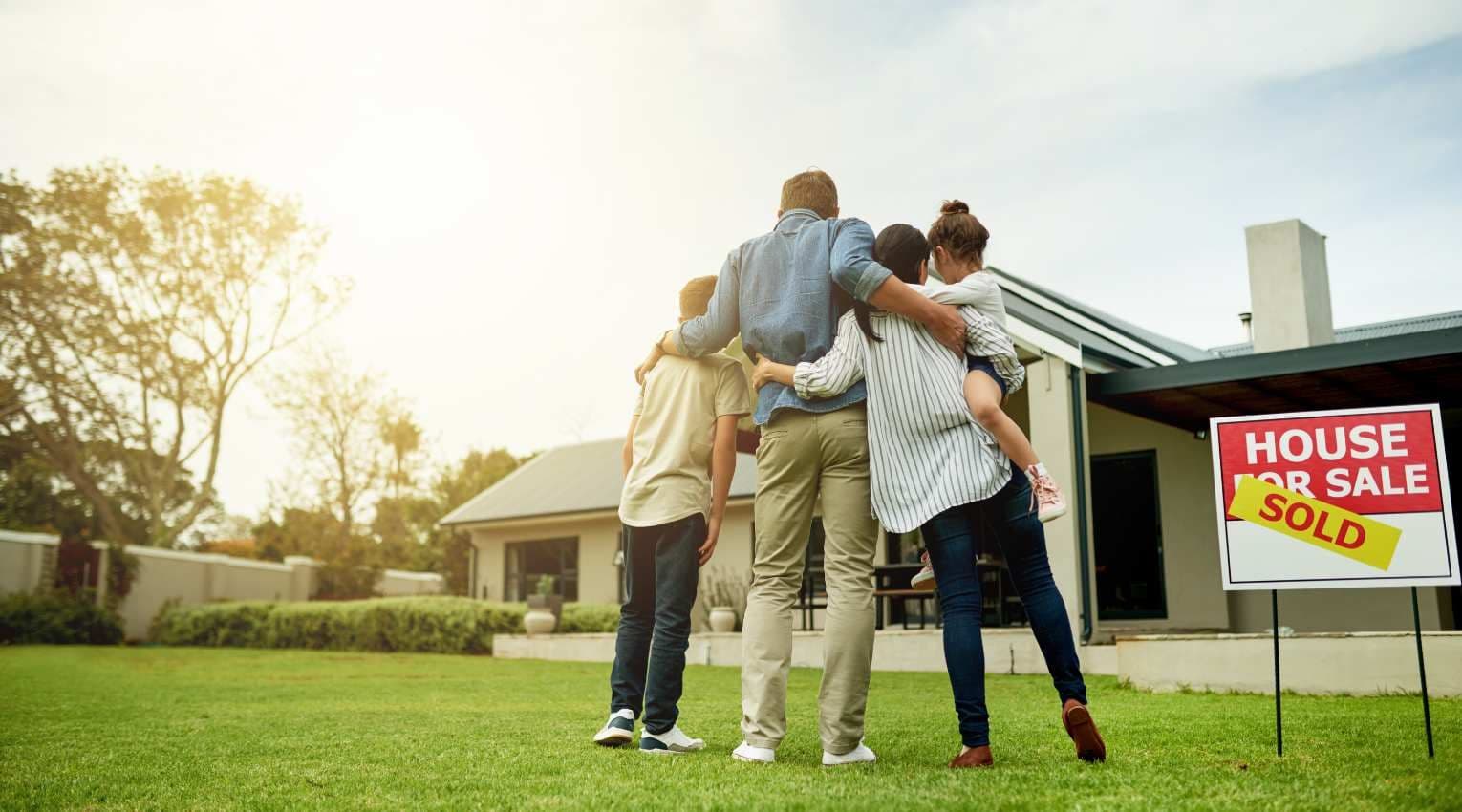 family of four facing newly-sold house